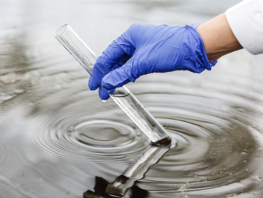 researcher-holds-test-tube-with-water-hand-blue-glove